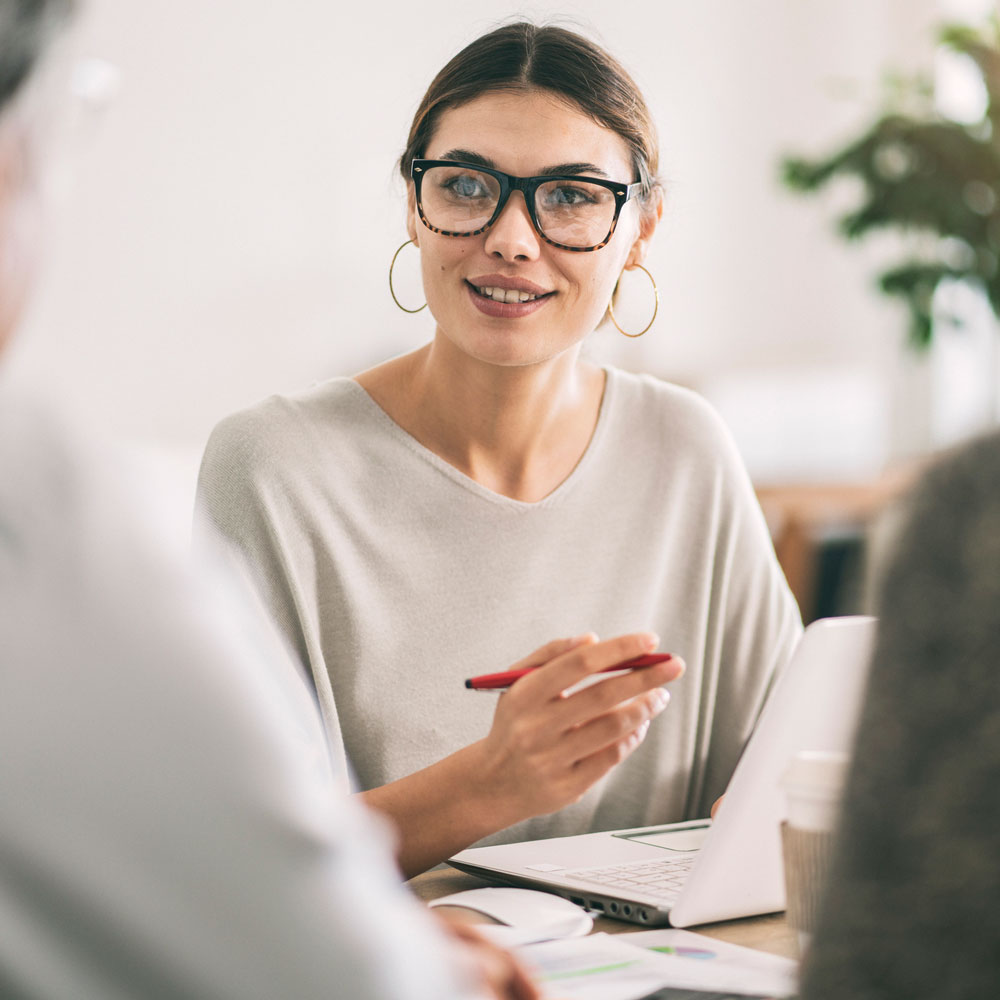 A professional talking with a couple seated mostly out of frame.